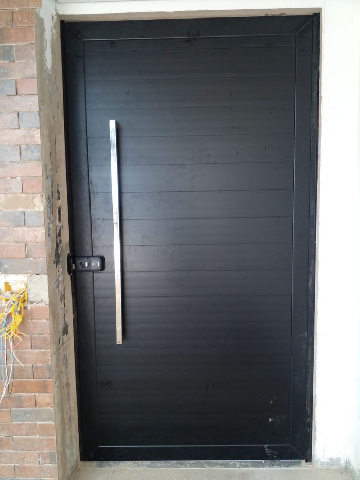 Porta pivotante em lambril de alumínio preto