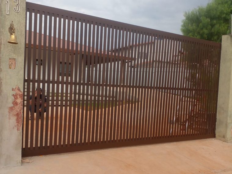 Portão de alumínio ripado com acabamento amadeirado